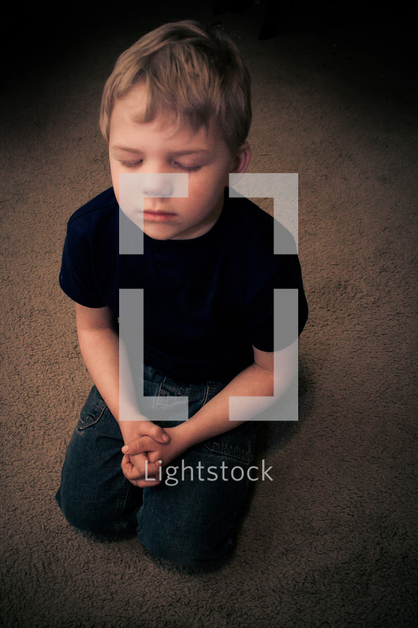boy child kneeling in prayer 