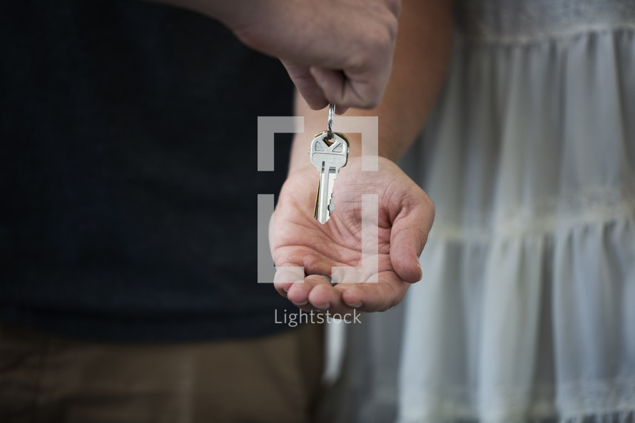 a man handing a key to a woman 