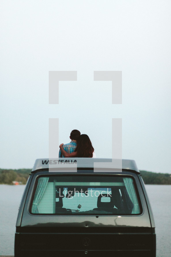 a couple standing beside a VW van