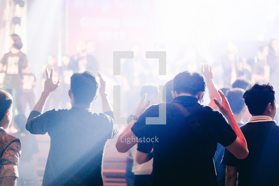 cheering and praying fans at a concert 