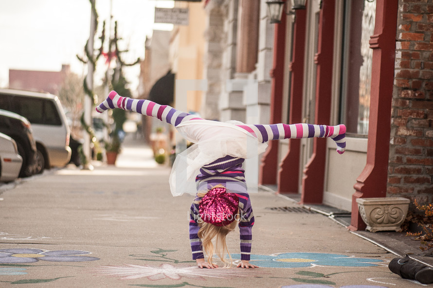 a girl child doing a cartwheel 