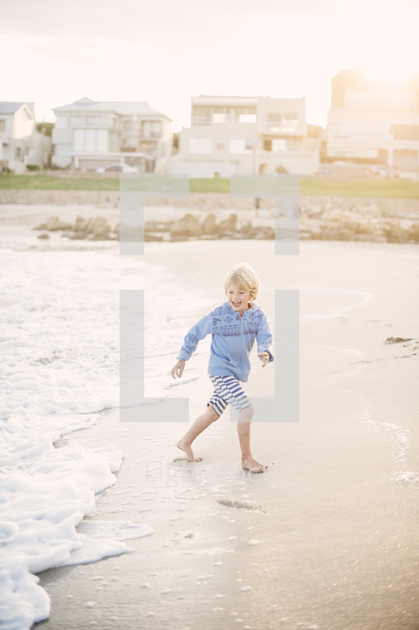 boy child running on a beach 