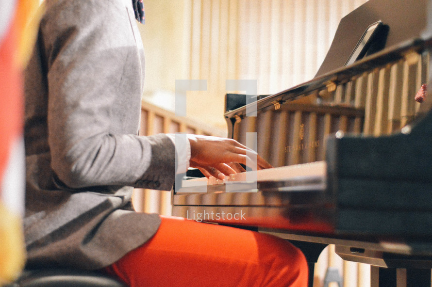 boys hands playing a piano 