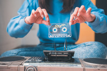woman holding a broken cassette tape 