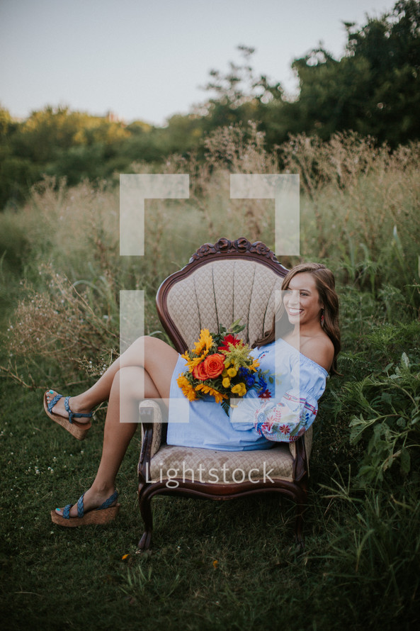 portrait of a young woman sitting in a chair outdoors 