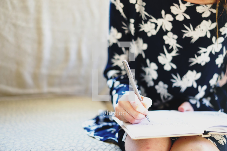 teen girl writing in a notebook 