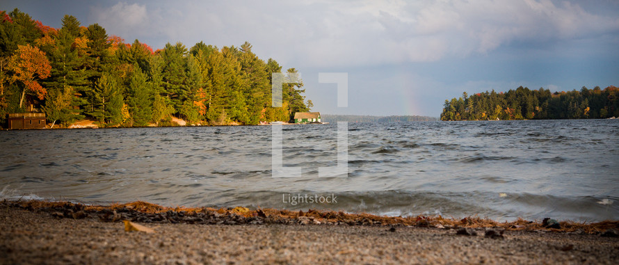 An rainbow covers the lake on a cool, autumn day.