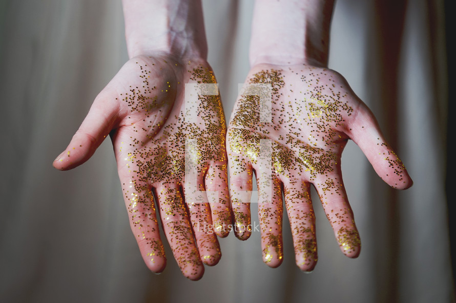 a woman with gold glitter on her hands 