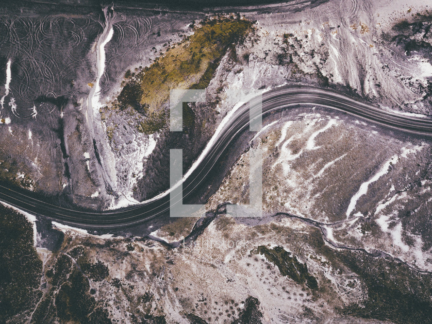 aerial view over a winding road on a snowy mountain 