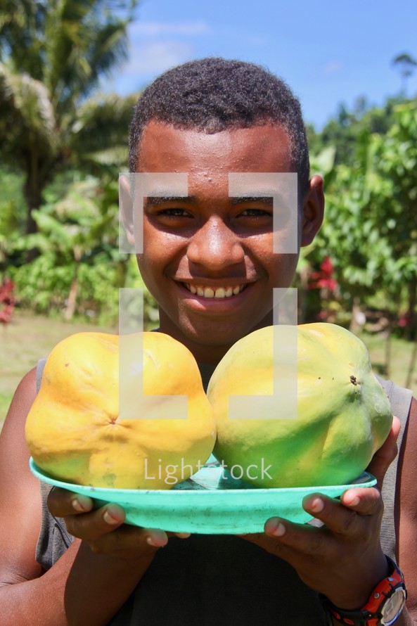 a boy holding fruit 