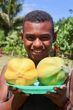 a boy holding fruit 
