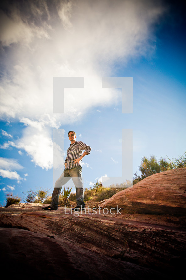 man standing on top of a rock in the desert