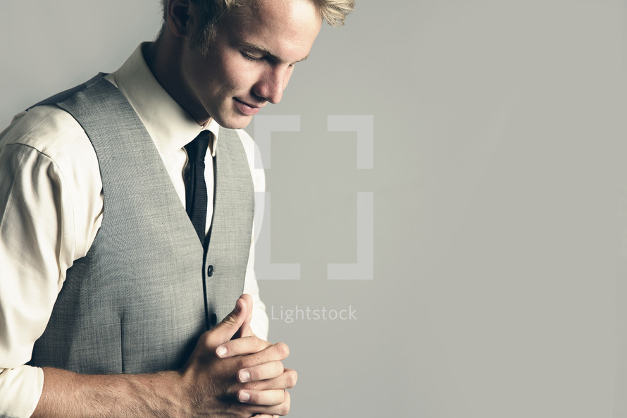 man in church clothes praying 