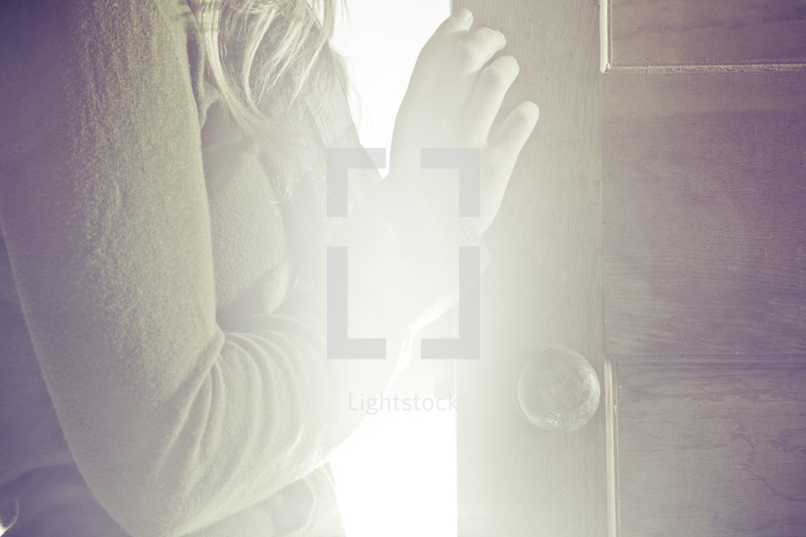 woman standing in the light of an opened door