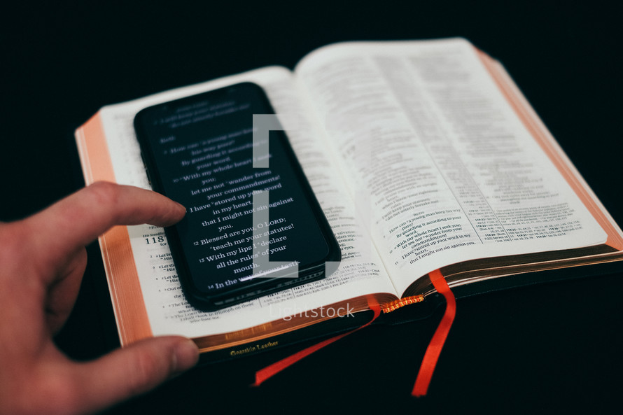 Bible app on a cellphone and on the pages of a Bible 
