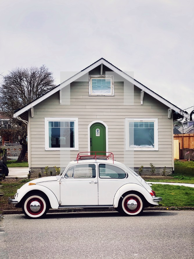old Volkswagen Beetle parked in front of a house 