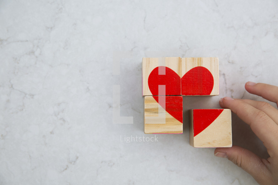 building a heart out of wood blocks 