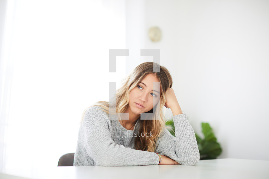 worried female sitting at a table 
