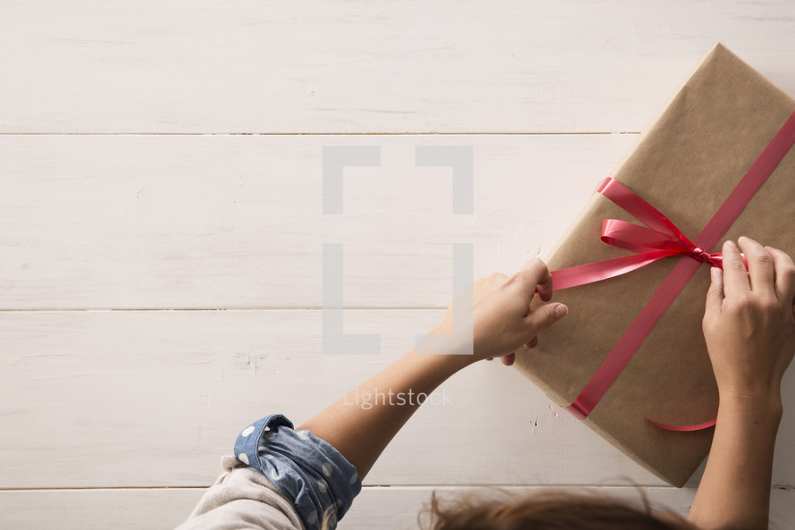 a woman wrapping a Christmas present 