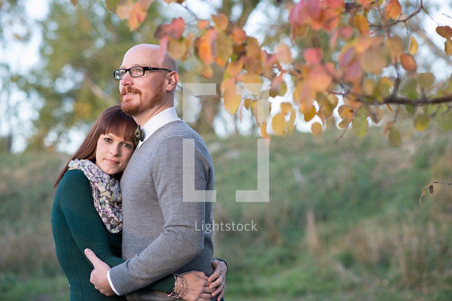 a couple hugging outdoors in the fall 