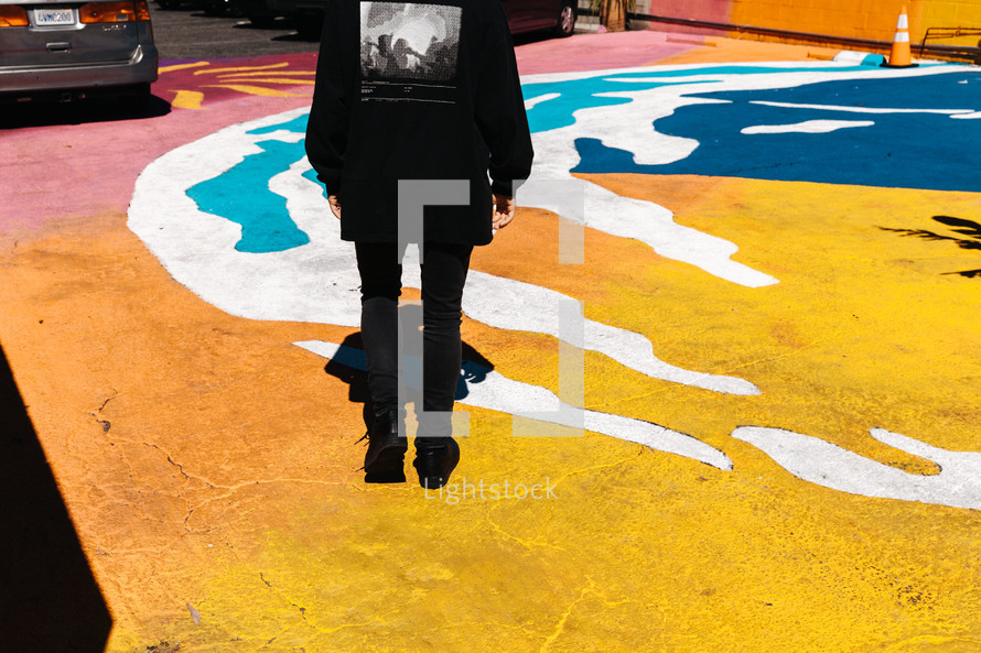 a man standing on a painting in a parking lot 