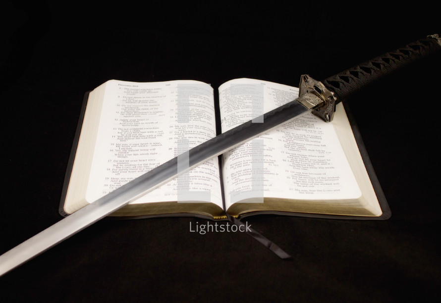 sword lying on the pages of a Bible