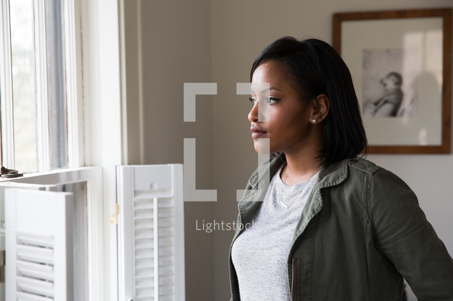 African American young woman standing in a window.
