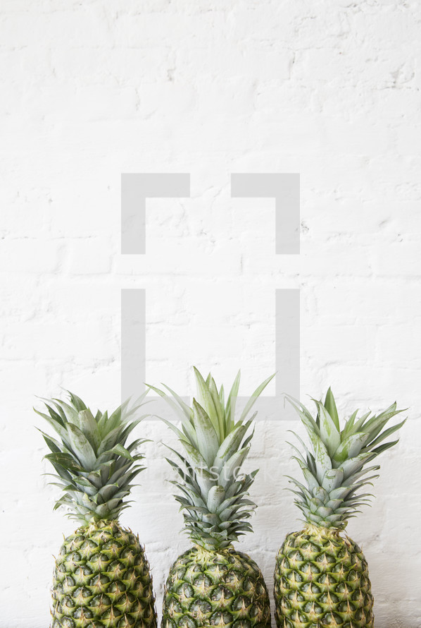 row of three pineapples 