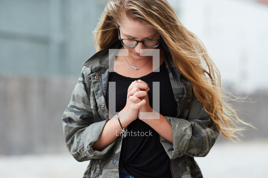 girl with head bowed in prayer 