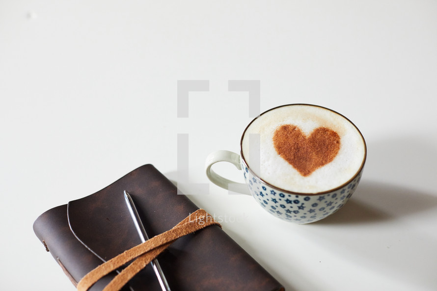 cinnamon heart in a coffee cup, Leather bound Bible, and pen
