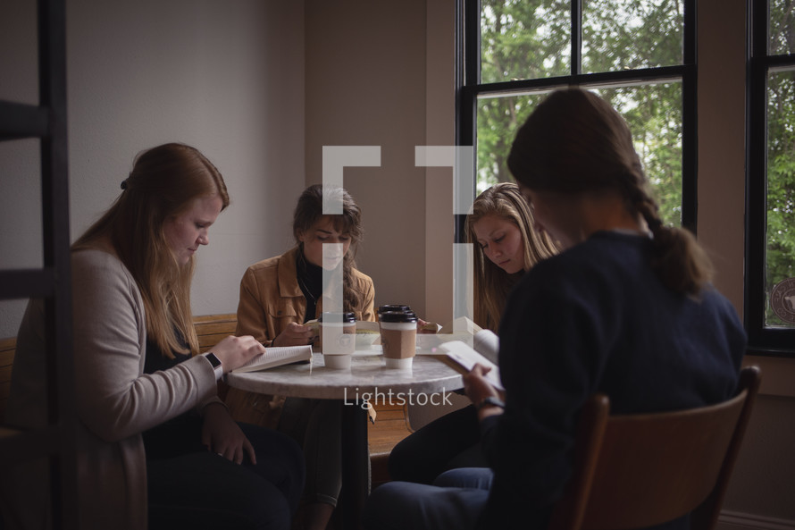 teen girls reading Bibles over coffee 