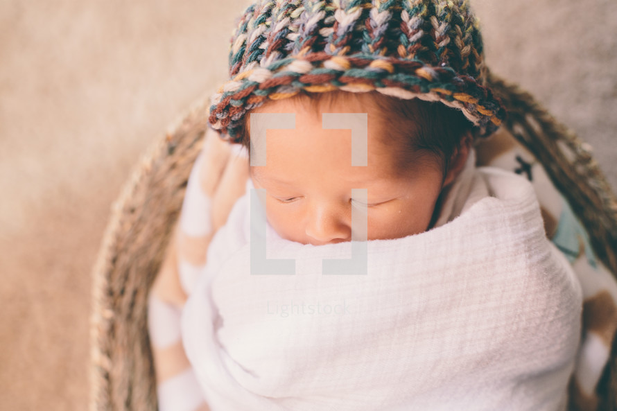 newborn sleeping in a basket 