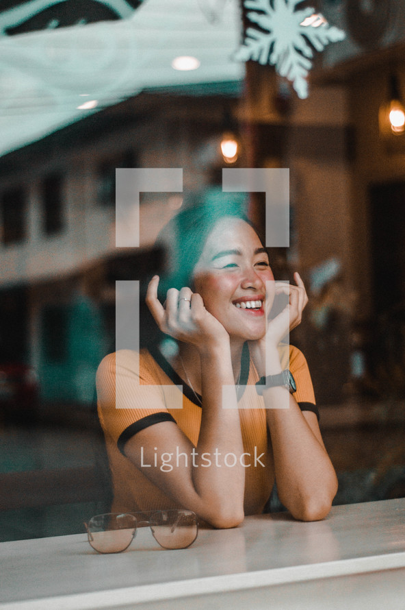 a smiling woman in a cafe window 