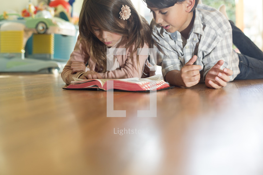 Brother and sister reading Bible together