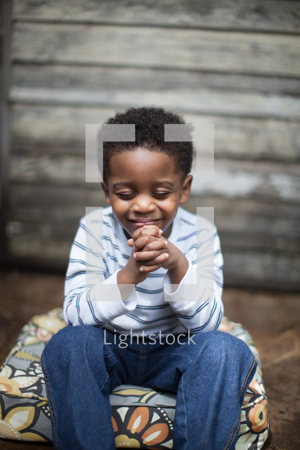 toddler boy sitting in prayer 