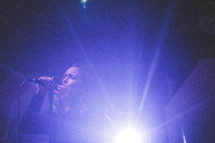 a woman singing into a microphone on stage 