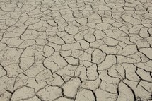 Parched clay soil in a dry lake bed during a drought 
