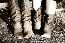 Two western pairs of boots worn by good friends dressed in cowgirl attire.