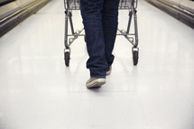 man pushing a shopping cart through a grocery store 