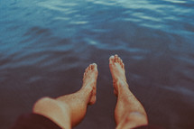 dangling feet over water 