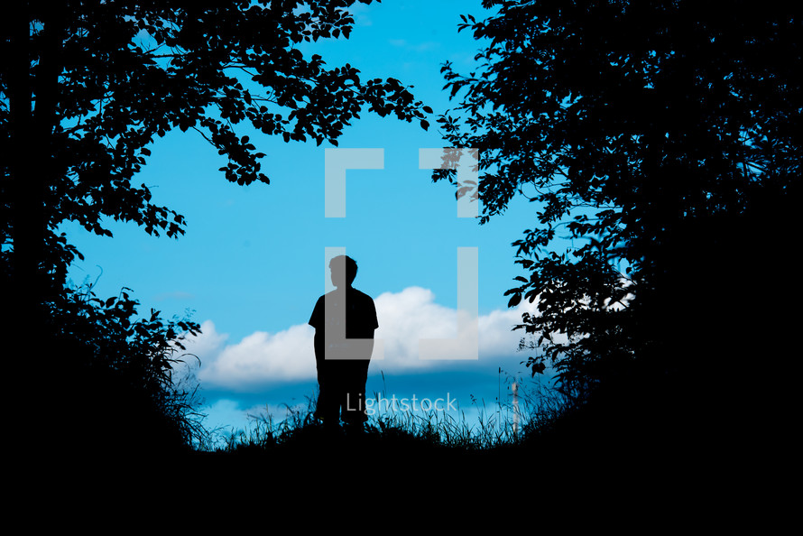 silhouette of a boy standing outdoors 