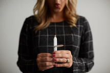 a woman holding a blown out candle 