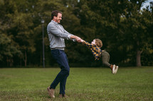 father swinging his son 