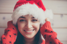 head shot of a woman in a Santa hat and Christmas sweater 