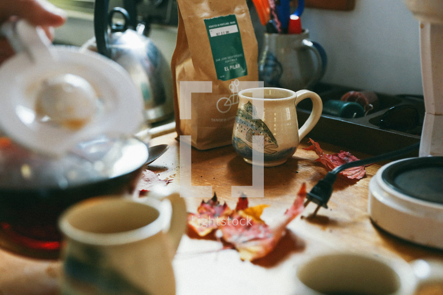 a messy counter top with coffee and coffee mugs 
