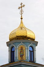 A church steeple with a golden dome and cross.