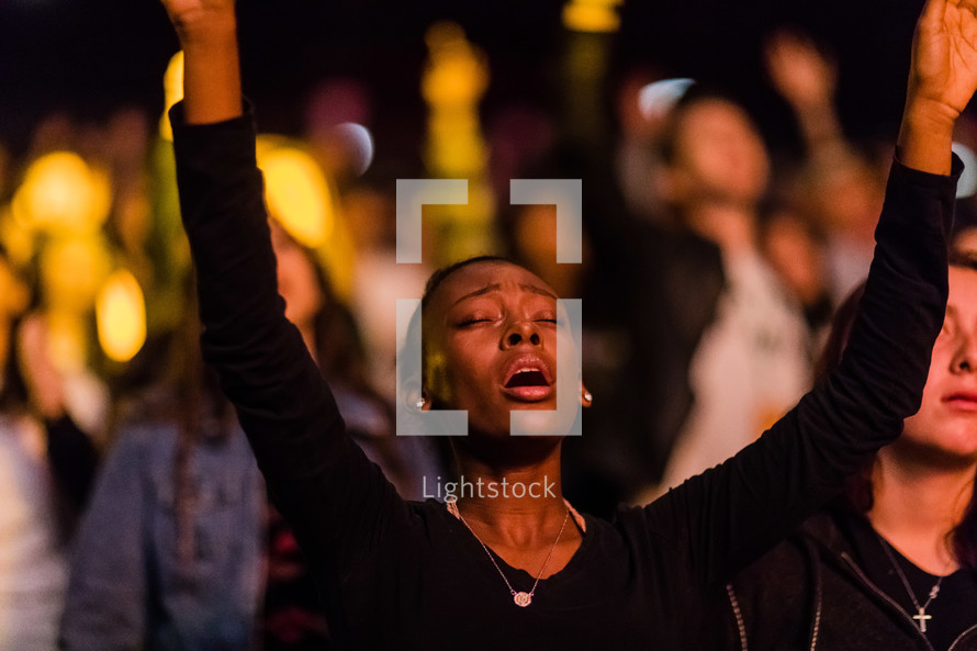 A woman with arms raised in praise and worship.