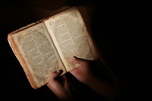 Woman reading old worn Bible