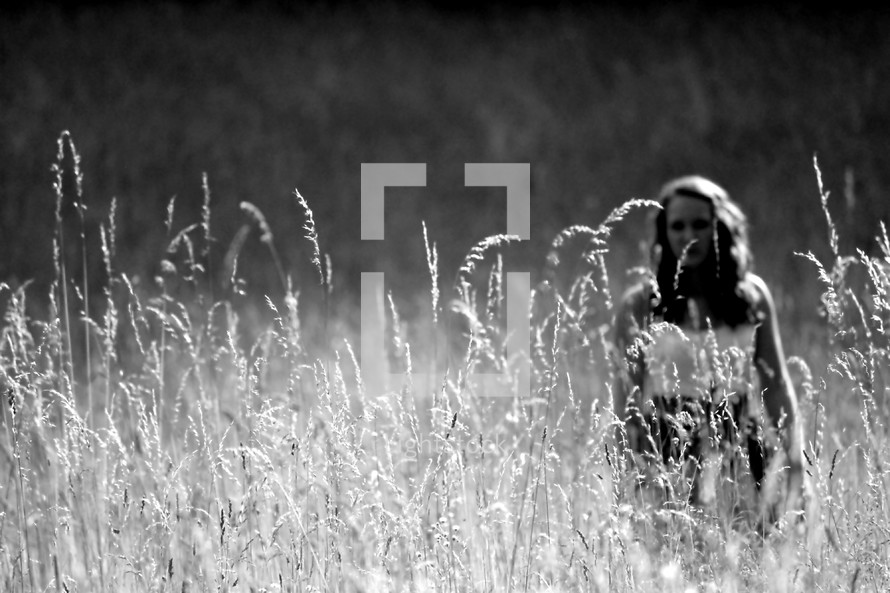 Woman standing in a field of tall grass.