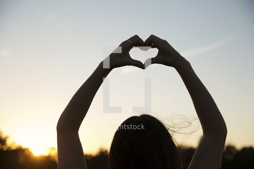 a woman making a heart with her hands 